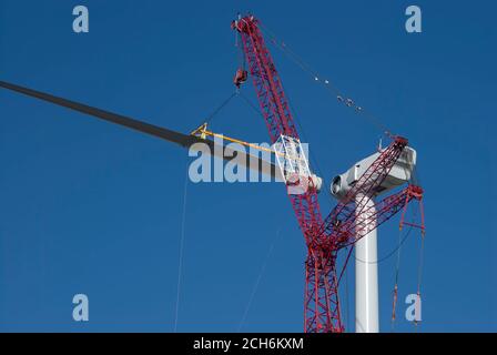 Grue géante soulevant la pale de l'éolienne à fixer à la nacelle lors de la construction d'un parc éolien à Rio Vista en Californie, près de Sacramento, pour le Sacrement Banque D'Images