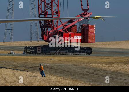 Grue géante soulevant la pale de l'éolienne à fixer à la nacelle lors de la construction d'un parc éolien à Rio Vista en Californie, près de Sacramento, pour le Sacrement Banque D'Images