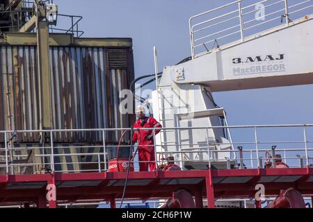 Gdansk, Pologne du Nord - 14 août 2020 : un ouvrier industriel en uniforme travaillant dans un chantier naval près de la rivière motlawa pendant une pandémie de couronne en été t Banque D'Images