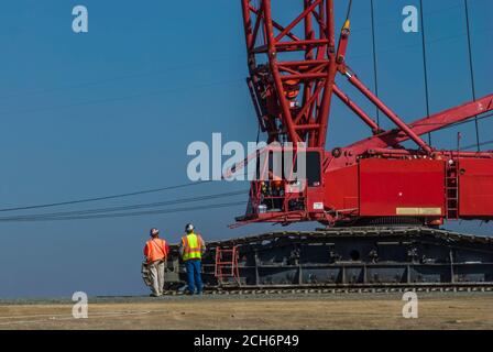 Des ouvriers de construction à côté d'une grue géante sont utilisés lors de la construction d'un parc éolien pour le district municipal de Sacramento, près de Rio Vista Califo Banque D'Images