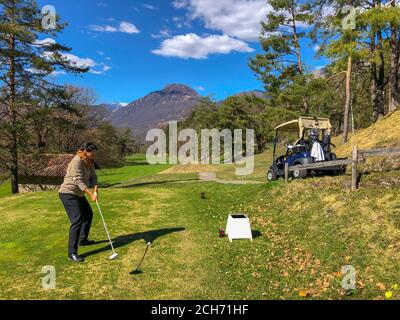 Golfeur Tearing Off avec chauffeur et avec vue sur la montagne en Italie. Banque D'Images