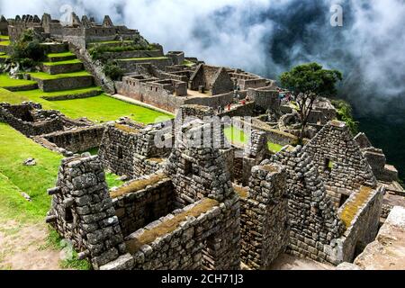 Les ruines anciennes de maisons résidentielles à Machu Picchu qui est un site Inca du XVe siècle situé dans la Vallée Sacrée des Incas au Pérou. Banque D'Images