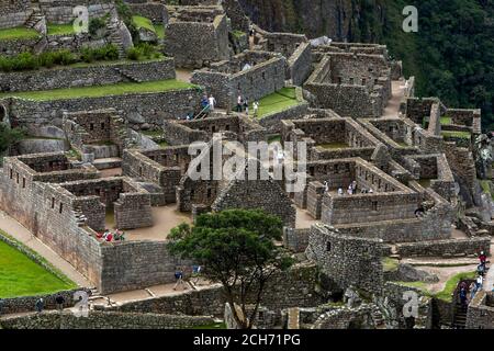 Les ruines anciennes de maisons résidentielles à Machu Picchu qui est un site Inca du XVe siècle situé dans la Vallée Sacrée des Incas au Pérou. Banque D'Images