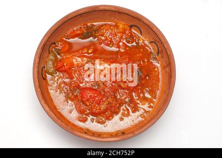 Assiette en argile à la tomate rôtie et compotée de poivron doux sauce sur blanc Banque D'Images