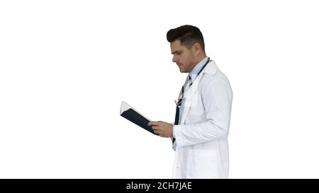 Médecin concentré lisant la documentation tout en marchant sur fond blanc. Banque D'Images