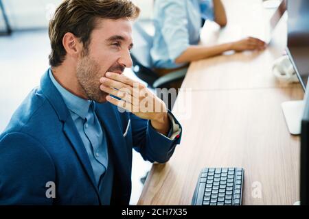 Employé fatigué surtravaillé sur le lieu de travail dans le bureau étant malheureux Banque D'Images