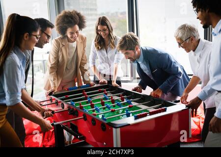 Les gens d'affaires ont passé un excellent moment ensemble. Collègues jouant au baby-foot au bureau. Banque D'Images