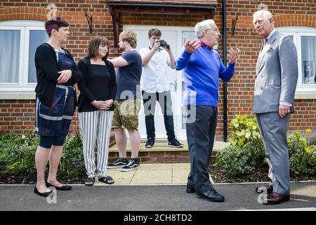 Le Prince de Galles rencontre Richard Kerslake et sa famille dans sa maison, lors d'une visite au développement de Mildren Homes sur le territoire duché de Cornouailles à Fordington, Dorset. Banque D'Images