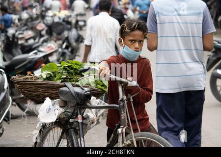 Dehradun, Uttarakhand/Inde - septembre 08 2020: Garçon vendant des légumes sur vélo portant un masque facial. Banque D'Images