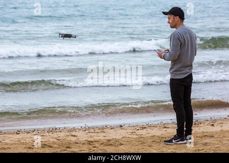 Jeune homme exploitant un drone lors d'un événement sur la plage de Bournemouth, Bournemouth, Dorset Royaume-Uni en septembre Banque D'Images