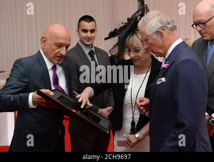 Le Prince de Galles rencontre Sir Ben Kingsley (à gauche) et Martina Milburn, chef de la direction du Prince's Trust (deuxième à droite) et reçoit un livre numérique des souvenirs contenant des messages enregistrés par des jeunes et des partisans du Prince's Trust,Lors d'une fête dans le jardin pour marquer le 40e anniversaire de la confiance au Palais de Buckingham à Londres. Banque D'Images