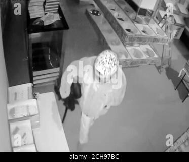 2 d'une séquence de 12. Prise de vue de CCTV émise par la police métropolitaine montrant un arsoniste masqué qui verse calmement de l'essence autour de la boulangerie Tavazo à Finchley, dans le nord de Londres, avant d'envoyer une vague de flammes dans le bâtiment. Banque D'Images