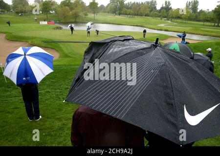 Les spectateurs tentent de s'abriter de la pluie sous un parapluie brisé pendant le premier jour de l'Open d'Irlande au K Club, dans le comté de Kildare.APPUYEZ SUR ASSOCIATION photo.Date de la photo: Jeudi 19 mai 2016.Voir PA Story Golf Irish.Le crédit photo devrait se lire comme suit : Brian Lawless/PA Wire.RESTRICTIONS : usage éditorial uniquement.Aucune utilisation commerciale.Pas de fausse association commerciale.Pas d'émulation vidéo.Aucune manipulation des images. Banque D'Images