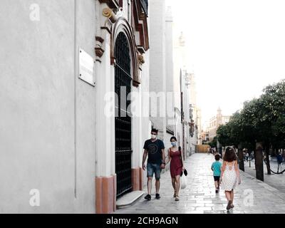 Séville, Espagne; 2 août 2020: Couple masqué marchant près de la cathédrale de Séville pendant la pandémie du coronavirus Banque D'Images