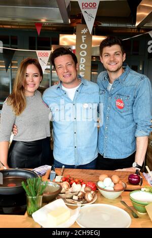 Jamie Oliver avec Tanya Burr (à gauche) et Jim Chapman (à droite) à sa Cookery School du centre commercial Westfield de Londres, lors du lancement d'un événement Facebook « live » qui mettra en vedette des chefs de dix pays encourageant les spectateurs à cuisiner des plats sains de zéro, Le jour de la Révolution alimentaire, qui fait partie de la campagne de la Révolution alimentaire, vise à s'attaquer aux problèmes de malnutrition et d'obésité chez les enfants. Banque D'Images