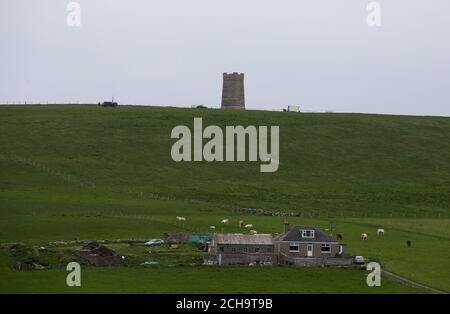 Les visiteurs se promondent le long des falaises au-dessus de la mer à Marwick Head à Orkney, où se dresse la tour construite pour honorer la mémoire de Lord Kitchener. Banque D'Images