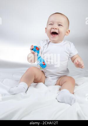 Photo d'un enfant de dix mois avec hochet bleu Banque D'Images