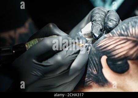 Maître faisant tatouage noir de serpent pour femme Banque D'Images