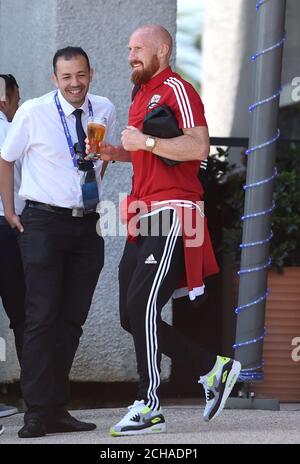 James Collins du pays de Galles, qui tient un verre, quitte l'hôtel Golden Tulip de Lyon. Le pays de Galles a été renversé à la demi-finale des Championnats d'Europe de 2016 après avoir perdu 2-0 au Portugal. Banque D'Images