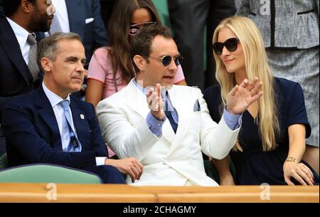 Invités de la Royal Box (gauche-droite) Mark Carney, Jude Law et Phillipa Coan le onze jour des Championnats de Wimbledon au All England Lawn tennis and Croquet Club, Wimbledon. Banque D'Images