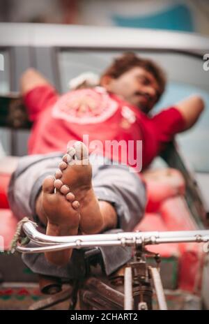 New Delhi, Inde - AOÛT 14 : un homme en pousse-pousse endormi attend des clients le 14 AOÛT 2016 à New Delhi, Inde. Banque D'Images