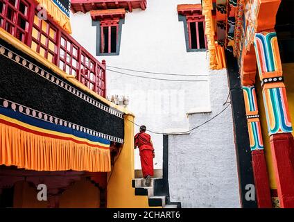 Monastère de Thiksay dans le village de Thiksey, Inde – 20 août 2016 : un jeune moine passe devant le monastère porté dans la kasaya rouge traditionnelle Banque D'Images