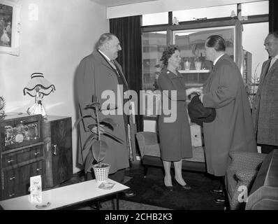 Herr Paul Lucke, ministre fédéral allemand du logement, secoue la main de Renee O'Brien lors d'une visite à son appartement à Cornish House, un bloc de 18 étages récemment achevé d'appartements de trois pièces à Southwark, Londres. Sur la gauche se trouve E.E. Woods, vice-président du conseil du comté de London. Banque D'Images