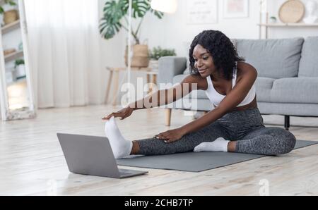 Petite fille noire qui fait de l'exercice matinal à la maison Banque D'Images