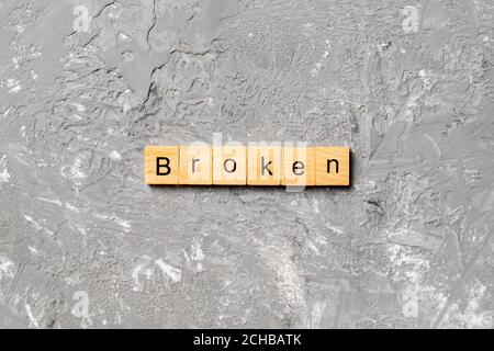 Mot CASSÉ écrit sur le bloc de bois. TEXTE CASSÉ sur la table de ciment pour votre conception, concept. Banque D'Images