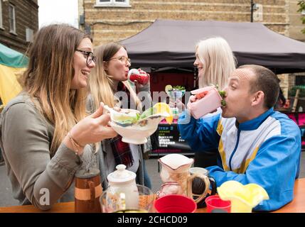 Un personnage hollandais fictif appelé « Arjen » (à droite), le héros improbable du recyclage dans le nord de Londres, bénéficie d'une queue de maquette « bin & tonique » dans la nouvelle pop-up « The Clog and Clown » de Whitecross Street Food Market, Islington. Banque D'Images