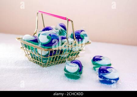 Dosettes de lessive pour lave-linge dans un mini panier. Trois capsules de gel ECO en une. Banque D'Images
