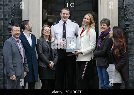 Le publican Jodie Kidd livre Jodie Kidd est rejointe par 5 attachés de presse alors qu'elle remet une pétition à un policier au 10 Downing Street demandant une réduction de la taxe sur la bière dans le budget d'automne, pour aider à soutenir les pubs locaux. Banque D'Images