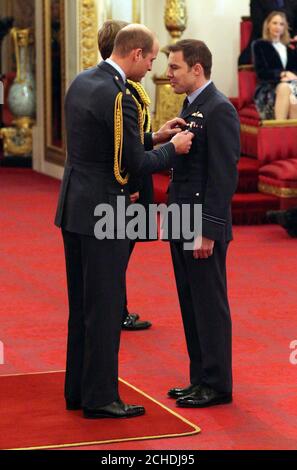 Le lieutenant de vaisseau Ben Wallis, de la Royal Air Force, est décoré de la Croix de la Force aérienne par le duc de Cambridge lors d'une cérémonie d'investiture au Palais de Buckingham, à Londres. Banque D'Images