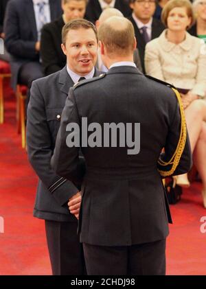 Le lieutenant de vaisseau Ben Wallis, de la Royal Air Force, est décoré de la Croix de la Force aérienne par le duc de Cambridge lors d'une cérémonie d'investiture au Palais de Buckingham, à Londres. Banque D'Images