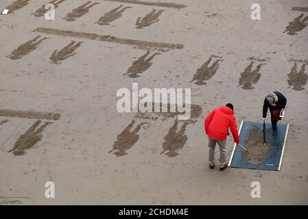 Les bénévoles de créer des dessins de plage sur les pages de la mer activité commémorative à Blackpool, sur le 100e anniversaire de la signature de l'Armistice qui a marqué la fin de la Première Guerre mondiale. Banque D'Images