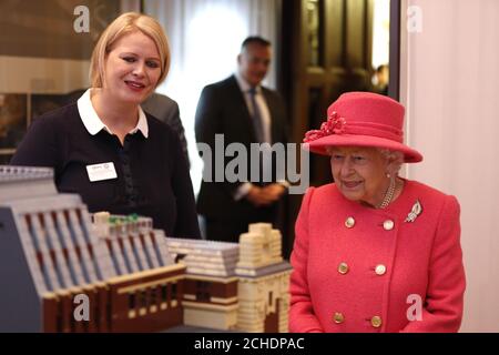 La reine Elizabeth II voit un modèle du bâtiment lors d'une visite à la Royal institution of Chartered Surveyors (RICS) à Londres, pour souligner son 150e anniversaire. Banque D'Images