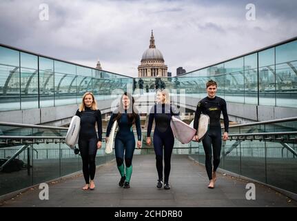 SOUS EMBARGO À 0001 MARDI 27 NOVEMBRE USAGE ÉDITORIAL SEULEMENT (de gauche à droite) Surfers Jessica Rowe, Veranika Lim, Sophie Hellyer et Frank Hodgson traversent le Millennium Bridge de Londres. Un partenariat est annoncé entre Lee Valley Regional Park Authority et The Wave afin de créer une destination de surf à l'intérieur de la capitale pour les personnes de tous âges, de tous horizons et de tous niveaux. Banque D'Images