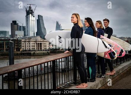 SOUS EMBARGO À 0001 MARDI 27 NOVEMBRE USAGE ÉDITORIAL SEULEMENT (de gauche à droite) Surfers Jessica Rowe, Veranika Lim, Sophie Hellyer et Frank Hodgson traversent le Millennium Bridge de Londres et Otilde. Un partenariat est annoncé entre Lee Valley Regional Park Authority et The Wave pour créer une destination de surf dans la capitale pour les personnes de tous âges, de tous horizons et de tous niveaux. Banque D'Images