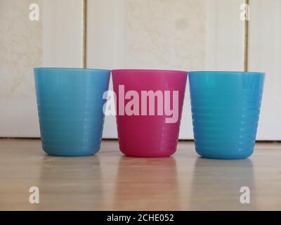 trois béchers en plastique colorés sur un plan de travail de cuisine en bois Banque D'Images