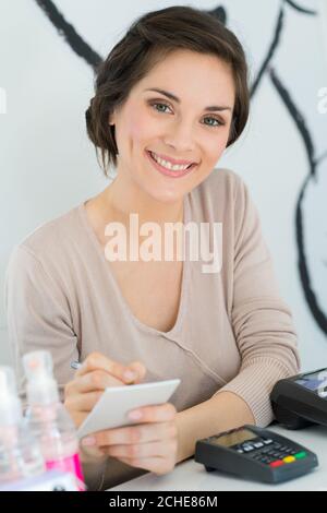 un jeune travailleur souriant compte de l'argent Banque D'Images