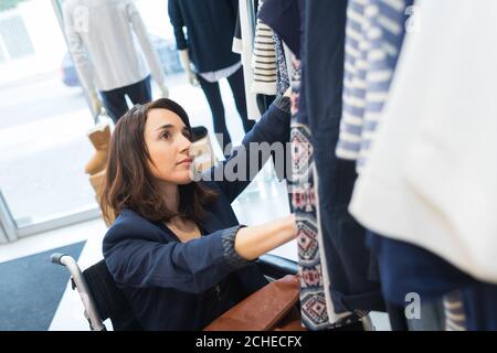 designer de mode en fauteuil roulant debout près d'un garde-robe Banque D'Images