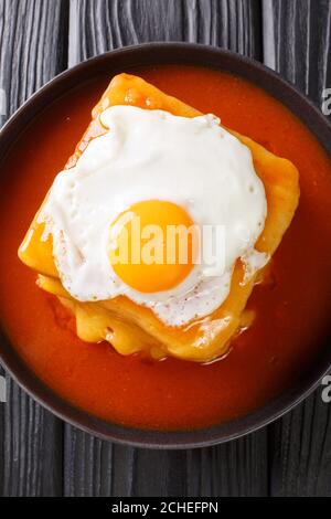 Francesinha est un sandwich unique composé de pain grillé, de boeuf, de saucisses, de jambon et de fromage, surgit dans une riche bière infusée sauce tomate en gros plan Banque D'Images