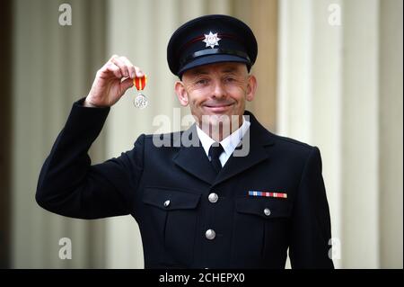 Le pompier Kevin Taylor avec la Médaille du service d'incendie de la Reine après une cérémonie d'investiture à Buckingham Palace, Londres. Banque D'Images