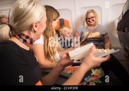 EMBARQUEMENT À 0001 MERCREDI 10 JUILLET USAGE ÉDITORIAL SEULEMENT (de gauche à droite) Danielle Cooper, membre de l'équipage, et les passagers Gabriella Day, 10 ans, Marcel Stec, 5 ans et Ella Woroszyl au lancement easyJet???s ???Flybraries??? Campaign, une initiative unique de prêt de livres à bord qui vise à encourager les enfants à lire pour s'amuser pendant l'été, à l'aéroport de Londres Luton. Banque D'Images