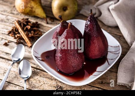 Poires pochées au vin rouge sur une table en bois Banque D'Images