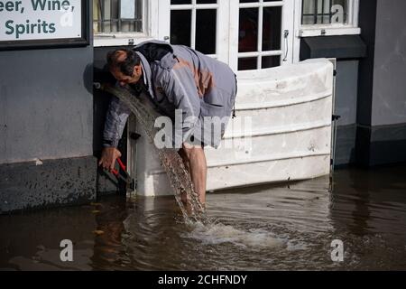 Un membre du personnel à la vue Bar à Worcester installe des défenses contre les inondations, que le Royaume-Uni a été frappé par des inondations généralisées après rivières sorties de leur lit après le week-end ? ? ?s une forte pluie. Banque D'Images