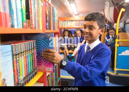 ADYAN Hussain, 10 ans, choisit un livre à lire avec les camarades de classe à bord de leur nouveau bus de bibliothèque, qui a été transformé par des collègues d'Epsom Sainsbury's dans le cadre de l'initiative communautaire de 150 jours du détaillant, à l'école primaire Riverview de Tolworth, Surrey.Photo PA.Date de publication : le mardi 29 octobre 2019.L'ancien bus londonien a été réaménagé et rénové dans le cadre du programme anniversaire de Sainsbury, qui a permis à 178,000 collègues du Royaume-Uni de se porter volontaires pour une cause de leur choix dans leur communauté locale.Le crédit photo devrait se lire: David Parry/PA Wire Banque D'Images