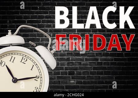 Concept du Vendredi fou. Réveil et inscription « Vendredi noir » sur fond de mur en brique noire Banque D'Images
