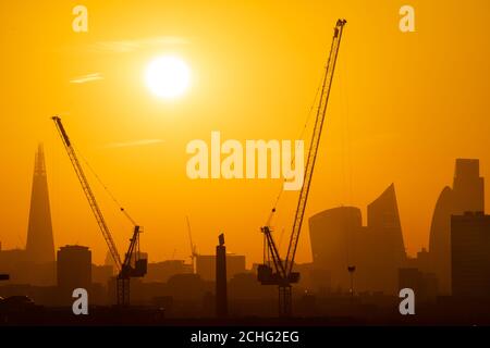 Le soleil se couche derrière les grues et les gratte-ciel de Londres, y compris le Shard (à gauche) et les gratte-ciels dans le quartier financier de la ville de Londres. Photo PA. Date de la photo: Mardi 21 janvier 2020. Le crédit photo devrait se lire comme suit : Dominic Lipinski/PA Wire Banque D'Images