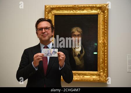 Directeur de Tate Britain Alex Farquharson avec le nouveau billet de £20 qui présente JMW Turner, devant une photo de l'artiste à la Tate Britain à Londres. Banque D'Images